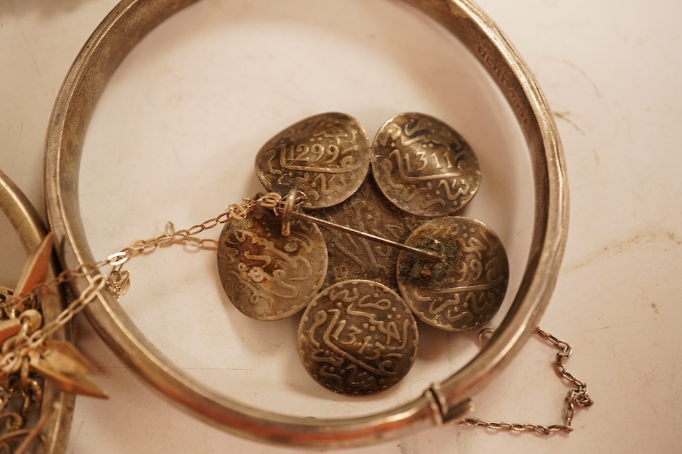 A small group of silver and white metal jewellery including Siamese enamelled bangle, silver chain, drop earrings, Persian coin brooch, etc.